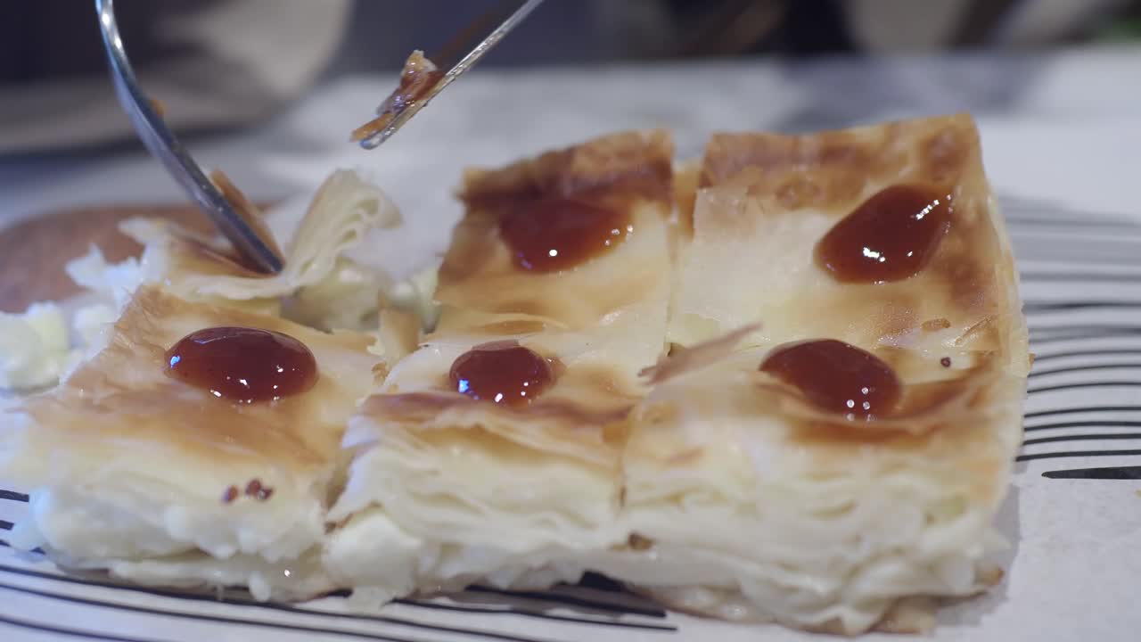 Close-up of a layered cheese pastry with sauce