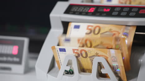 modern electronic money counting machine working. fifty euro banknotes being counted quickly. close up.