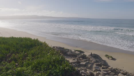 Slow-motion-shot-of-a-sunny-day-at-with-relaxing-waves-at-California-Monterey-Bay-Marina-State-Beach