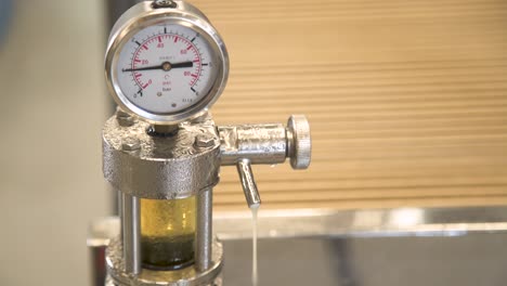 pressure gauge with condensation bubbling and dripping liquid, closeup