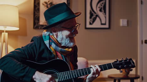 an older man playing an acoustic guitar in his living room