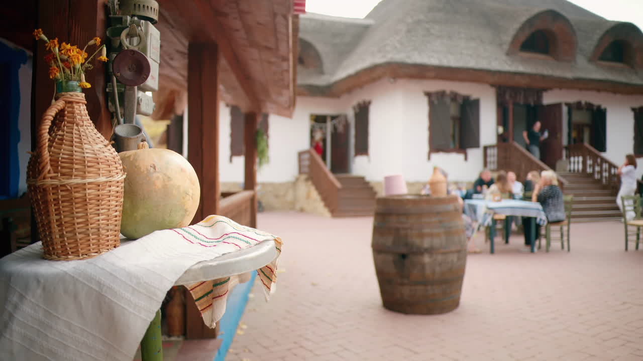 Traditional elements and resting people in a winery-restaurant in a village, Moldova. National wine and towel, traditional houses. Slow motion