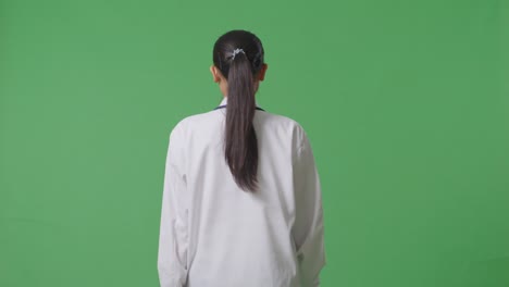 vista trasera de una doctora asiática con estetoscopio caminando en el fondo de la pantalla verde en el hospital