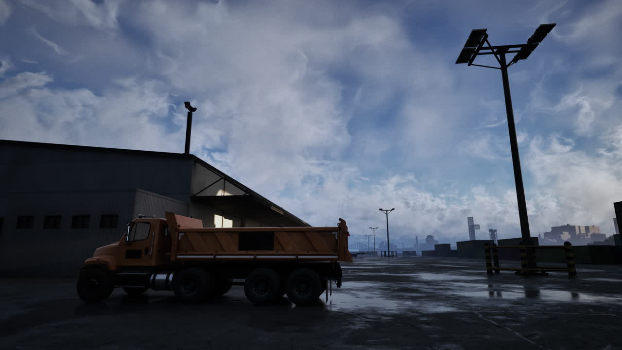 A dump truck parked in front of a warehouse at night