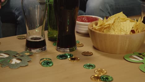 cerca de amigos en casa o en el bar celebrando en la fiesta del día de san patricio bebiendo alcohol con novedades y bocadillos