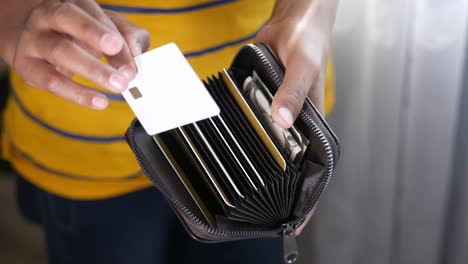 man die een creditcard uit een portemonnee haalt