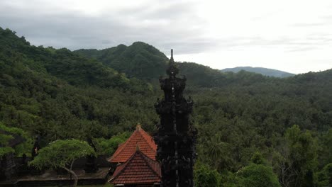 carved shrine tower in hindu temple surrounded by dense jungle vegetation, bali