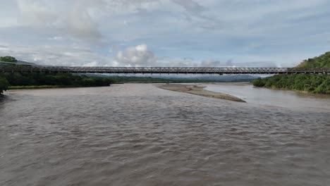 Aufschlussreiche-Drohnenaufnahme-Der-Puente-De-Occidente,-Einer-Historischen-Brücke-In-Kolumbien-über-Dem-Fluss-Cauca