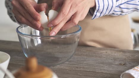 the eggshell is broken by hand. girl breaks hands breaks breaks eggs. beats the shell of a white egg