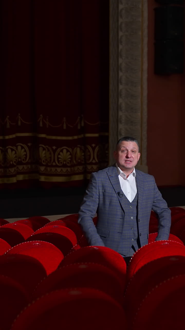 Empty theater because of pandemic. Beautiful interior of big concert hall with one man in the middle. Lockdown time. Vertical video