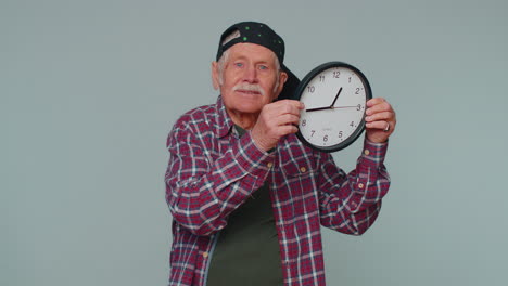 Senior-man-holding-clock-watch,-hiding,-checking-time-on-clock,-running-late-to-work-being-in-delay