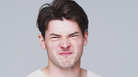 head and shoulders studio shot of angry man shouting at camera in slow motion