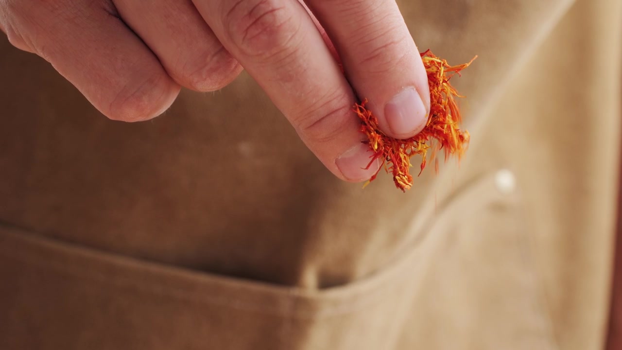 Close-up of Hand Sprinkling Saffron Spice in Slow Motion
