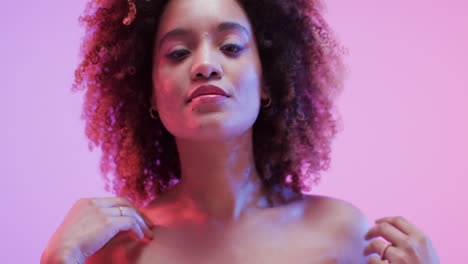 mujer biracial con cabello rizado oscuro en luz azul y rosa, cámara lenta