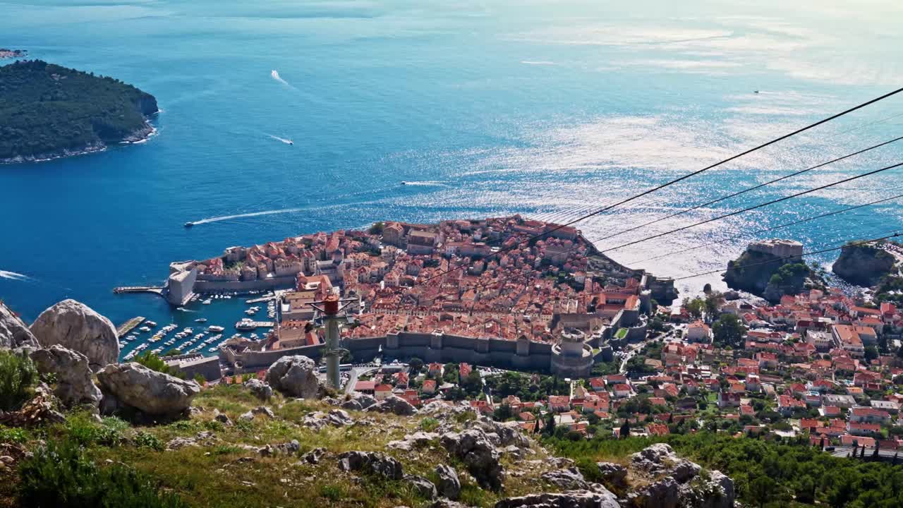 Wide-angle landscape view from Mount Srđ captures Dubrovnik’s Old Town with terracotta rooftops, historic streets, and the deep blue Adriatic Sea stretching into the distance, highlighting the city