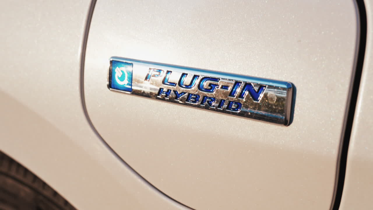 Shining close up of a plug in hybrid badge on a car under sunlight