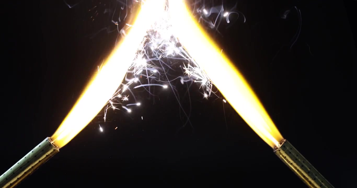 Burning sparklers held at angle emitting bright golden light