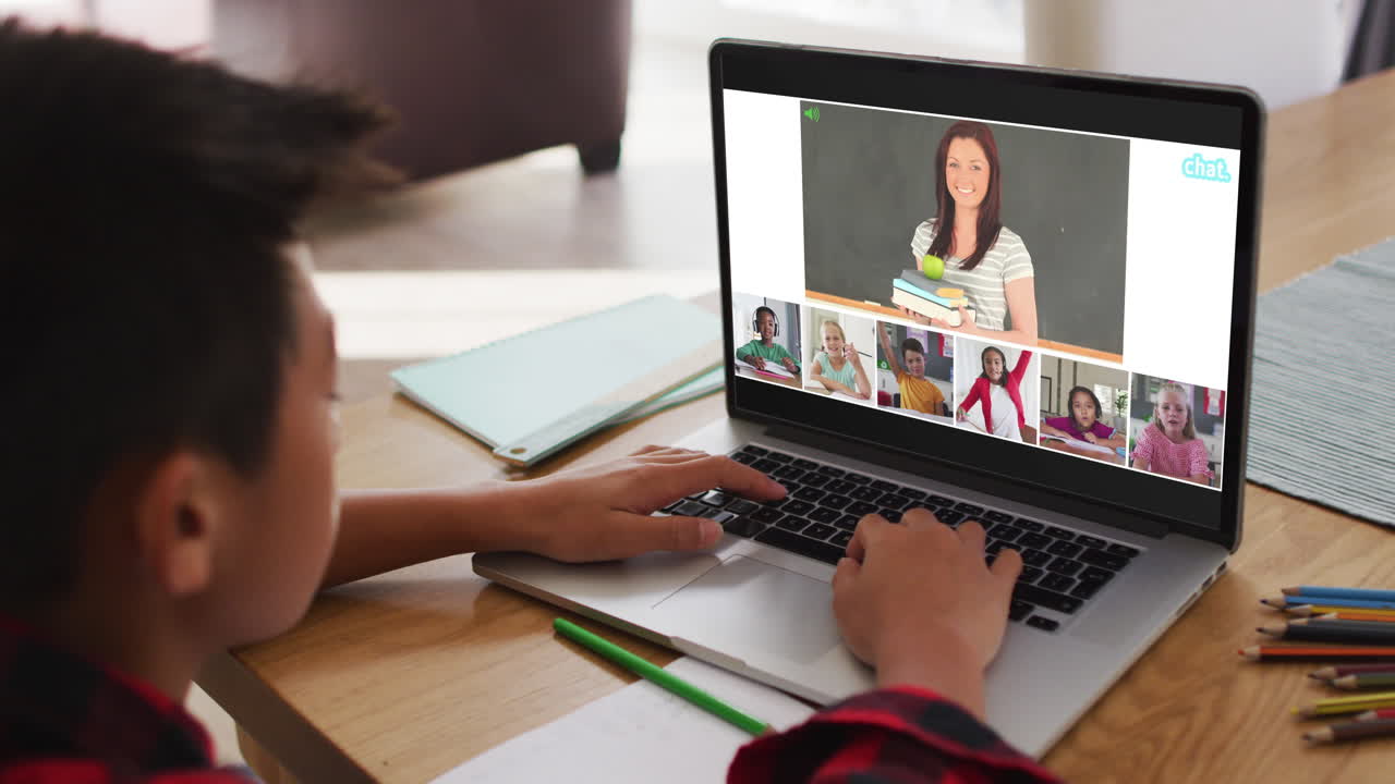 niño asiático teniendo una videoconferencia con el maestro y sus compañeros de clase en la computadora portátil en casa