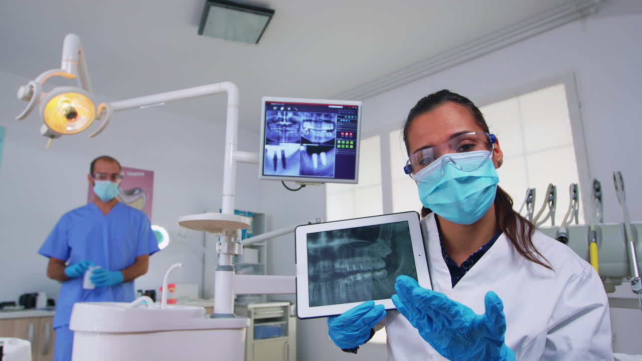paciente al dentista mostrando en la tableta rayos x de los dientes