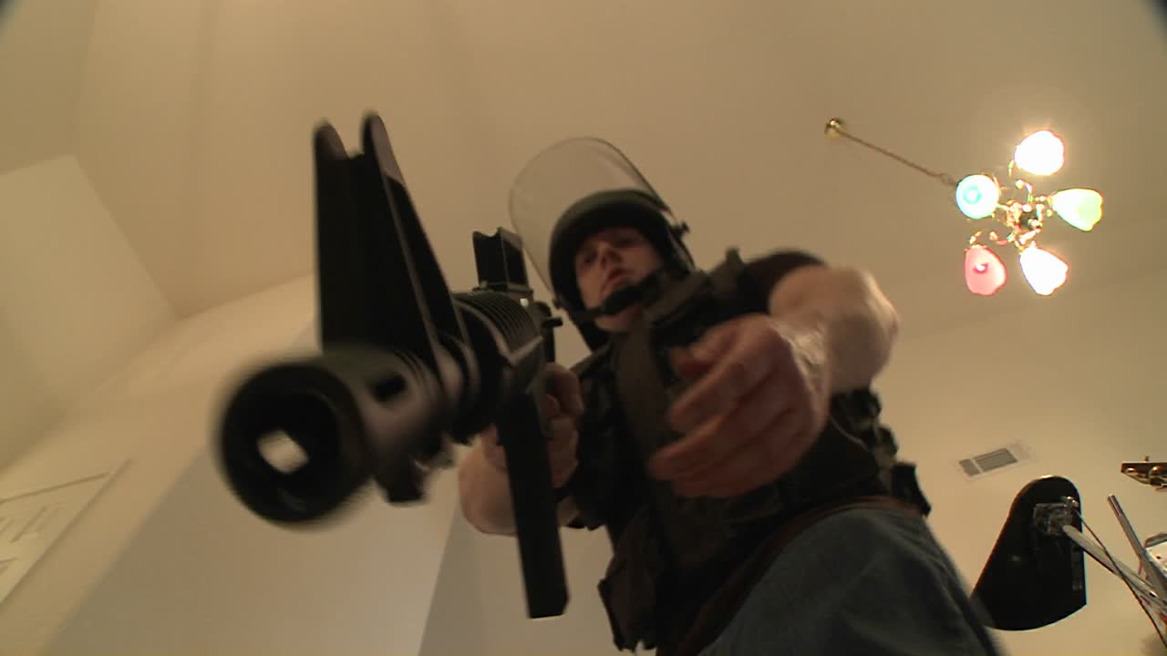 마약 단속 중 집을 비우고 용의자를 총구 2에 붙잡고 있는 경찰과 함께 한 스왓 팀