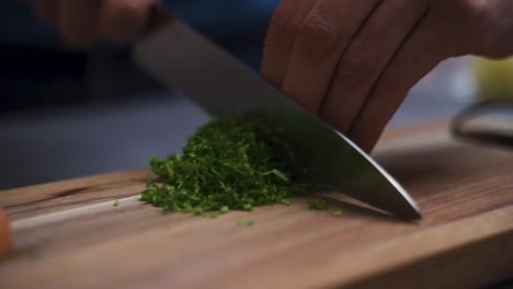 chef chopping herbs on a wooden board