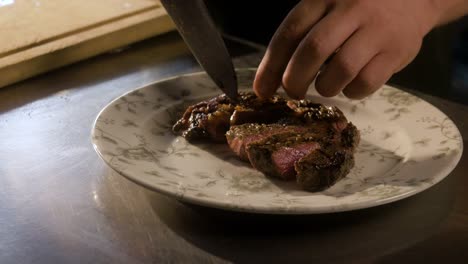 el chef sirve bistec cortado en un plato