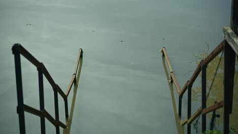 Partially submerged metal stairs descending into calm water in Lonjsko Polje Krapje Croatia