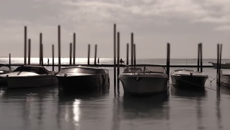 boats moored in a marina at sunset with reflections on the water