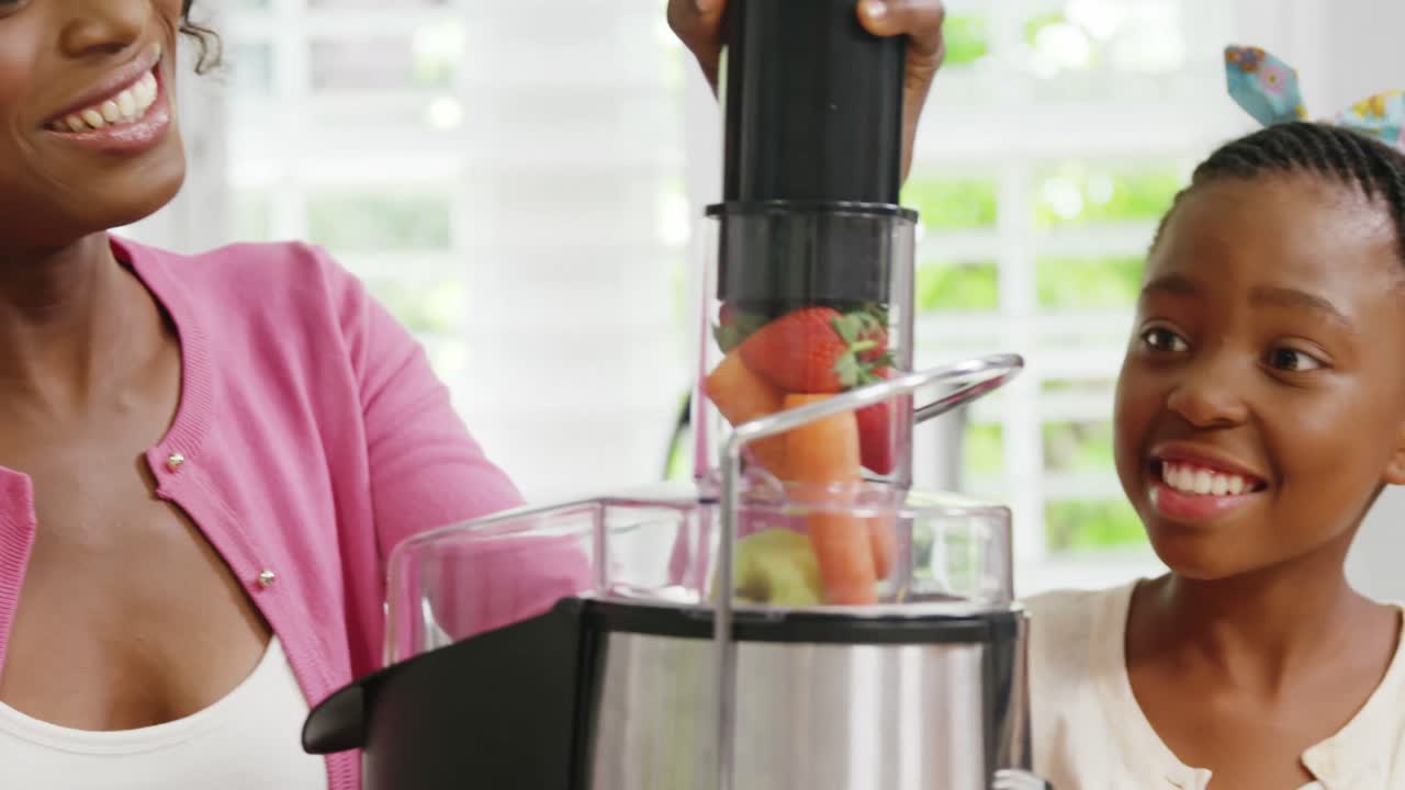 madre e hija preparando jugo en la exprimidora