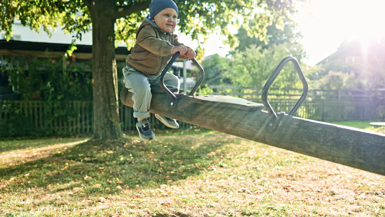 Bambino sull'altalena. Bambino felice che ride e si dondola sull'altalena al parco. Bambino piccolo sull'altalena nel parco giochi in una giornata di sole