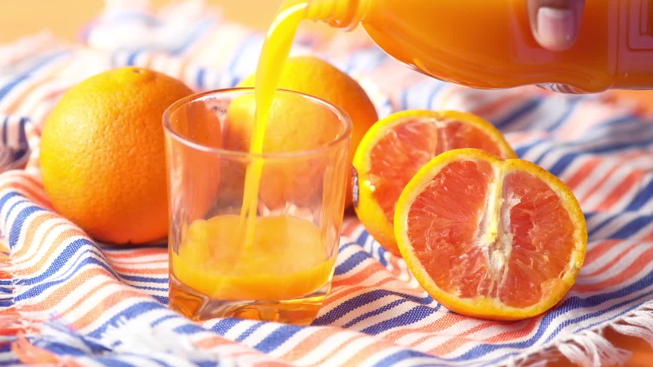 Versare il succo d'arancia in un bicchiere