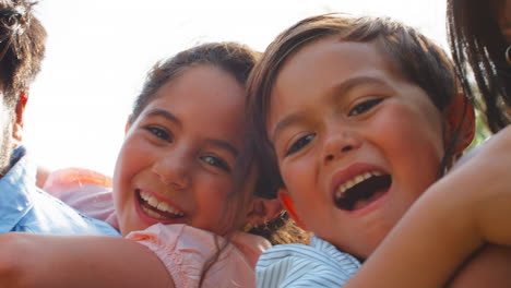 retrato de la familia al aire libre en el jardín o en el campo con los padres dando a los niños mochilas