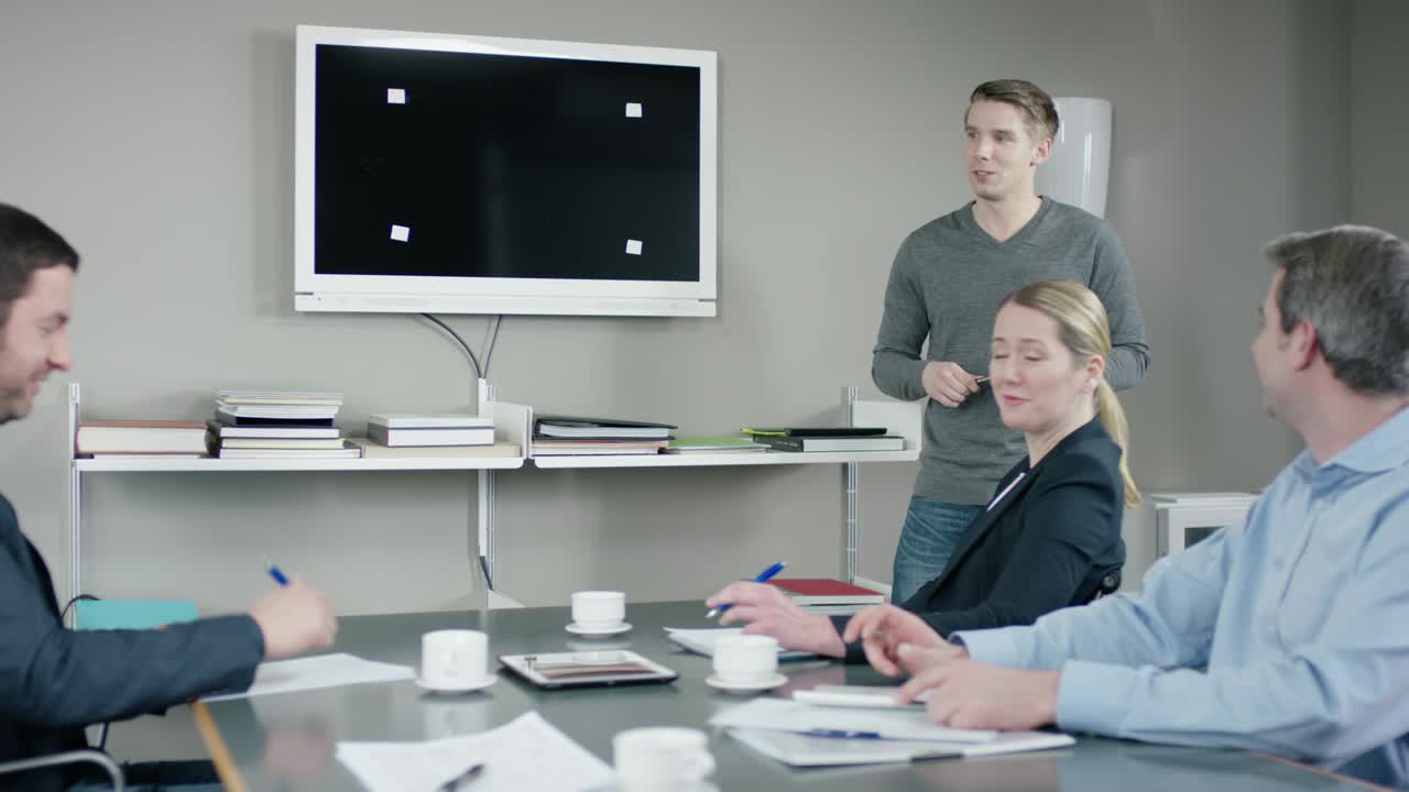Young employee gives a presentation to his colleagues at a meetingroom