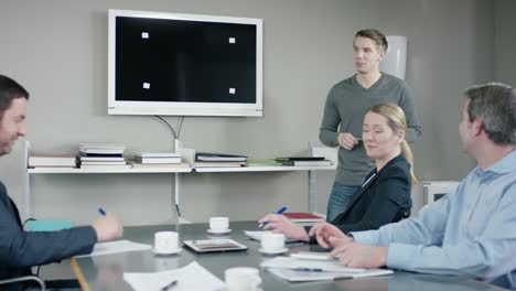 young employee gives a presentation to his colleagues at a meetingroom