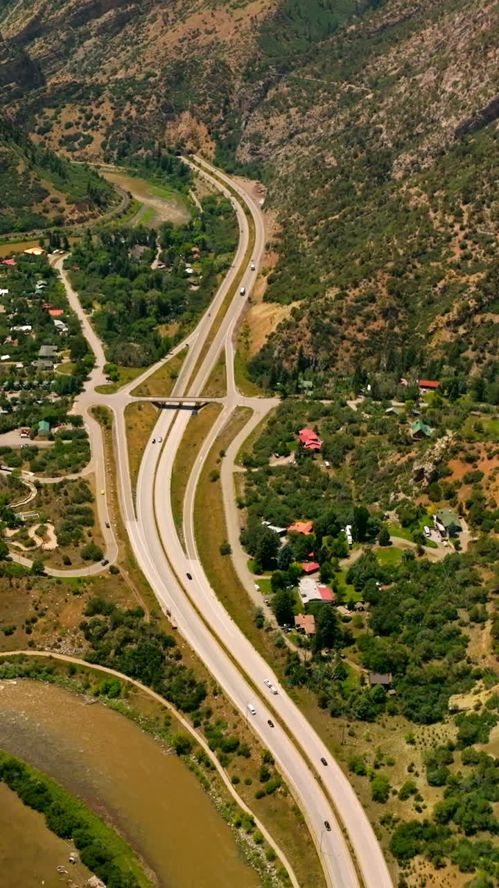 Delightful scenery of resort town in the mountains. Beautiful town locating between the river and speed highways. Top view. Vertical video