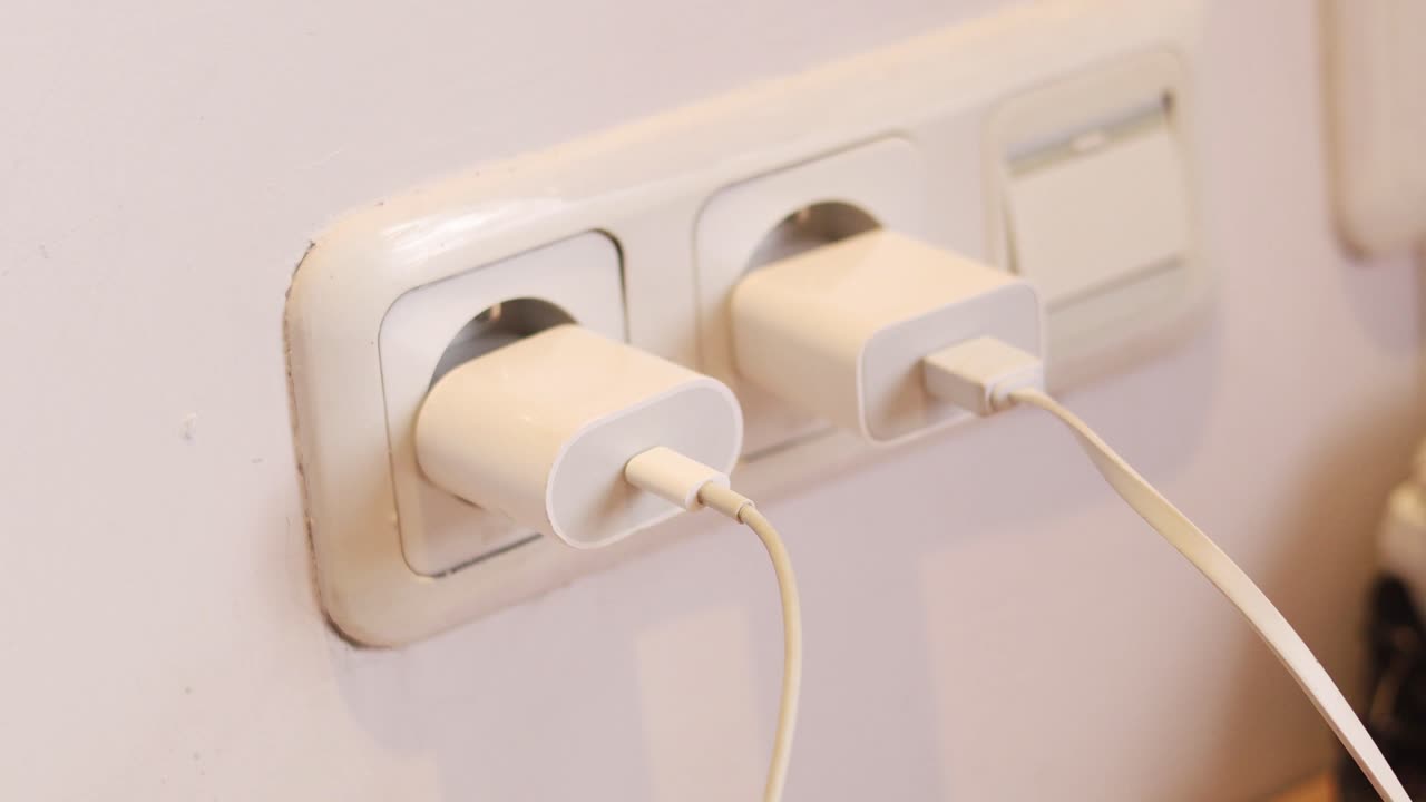 Close up of hand unplugging power cord into socket to save energy