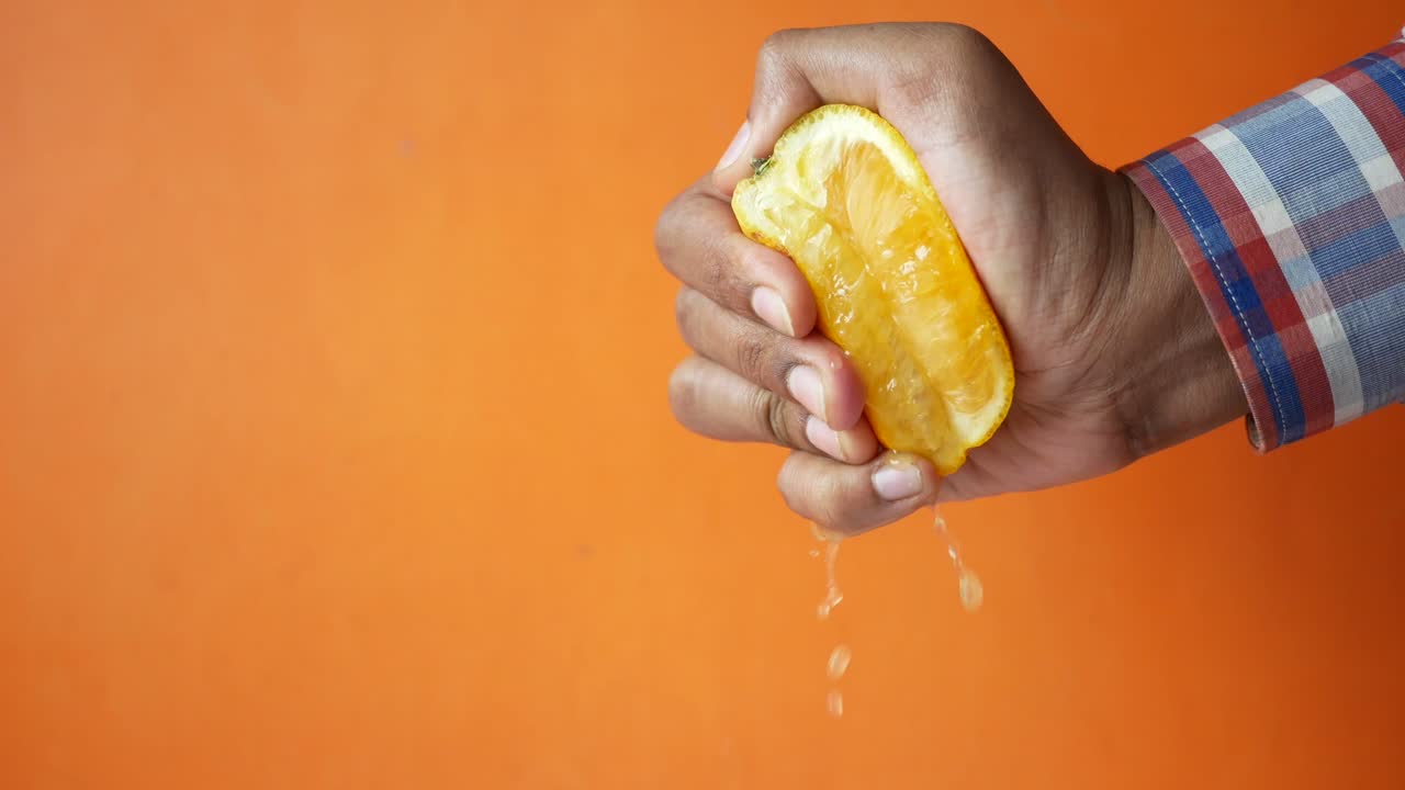 apretando la naranja con la mano