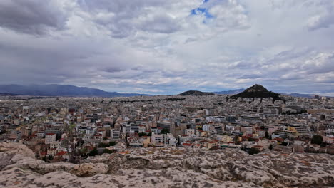 panoramic view of athens city with mount lycabettus on cloudy day, panning view