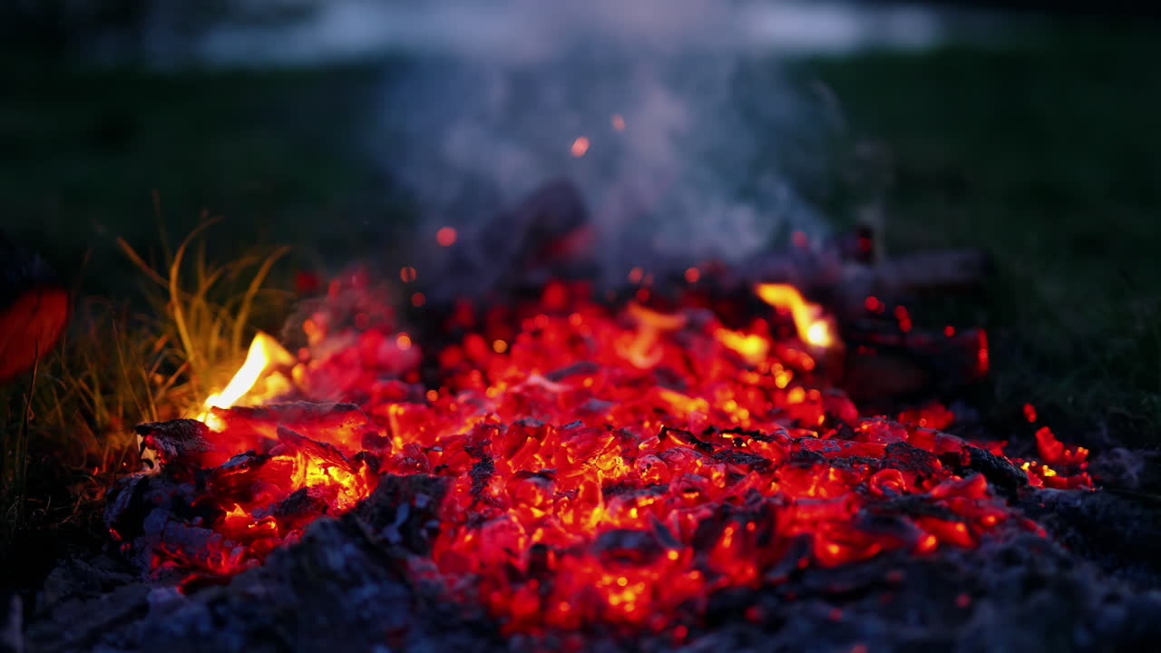 Burning firewood in the fireplace. Red live coals in the oven against black background