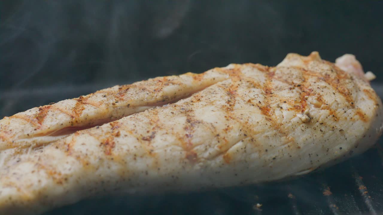Kitchen Tongs Flipping Chicken Steak Cooked on Hot Grill