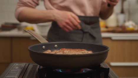 persona de la cosecha girando salchichas caseras fritando en sartén
