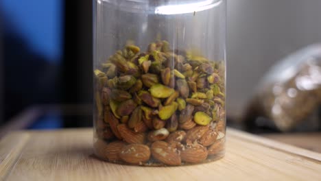 macro shot of mixed nuts filling plastic jar. healthy vegan snack
