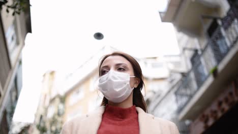 Beautiful-girl-wearing-protective-medical-mask-and-fashionable-clothes-stands-at-street