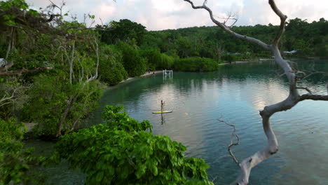 Pullback-Over-Woman-Stand-up-Paddle-Boarding-At-Sunrise-On-Moso-Island,-North-Efate,-Vanuatu