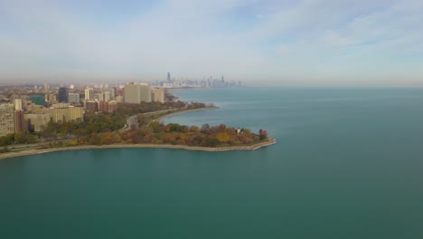 Horizonte-De-Chicago-En-La-Distancia,-Alta-Vista-Aérea-Desde-El-Lado-Sur-Sobre-El-Lago-Michigan