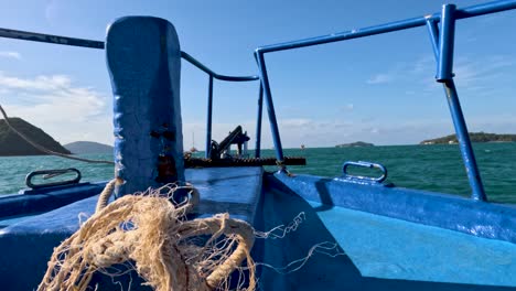 un barco de pesca navega por las aguas turquesas de phuket, tailandia, bajo cielos despejados, capturando la esencia de la aventura marítima