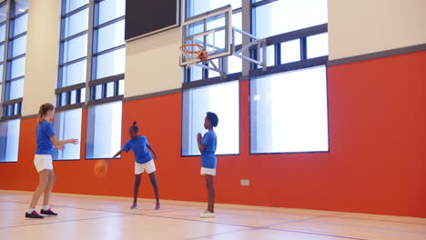 playing basketball in school gym, kids practicing shooting and passing