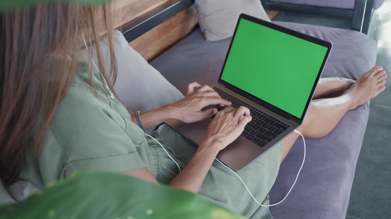 persona con una computadora portátil de pantalla verde en el sofá