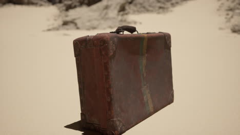 vintage suitcase on sand