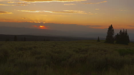 golden summer sunset over mountain and fields. time-lapse